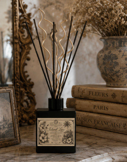 Close view of Island Lace Reed Diffuser label with ornate botanical illustration on matte black glass